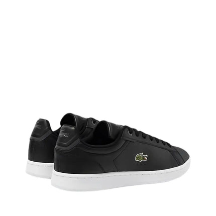 lacoste carnaby sneakers placed beside carry-on luggage at Tampa International Airport

